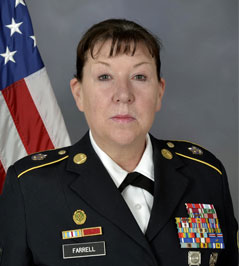 Catherine Farrell in uniform with flag in background.