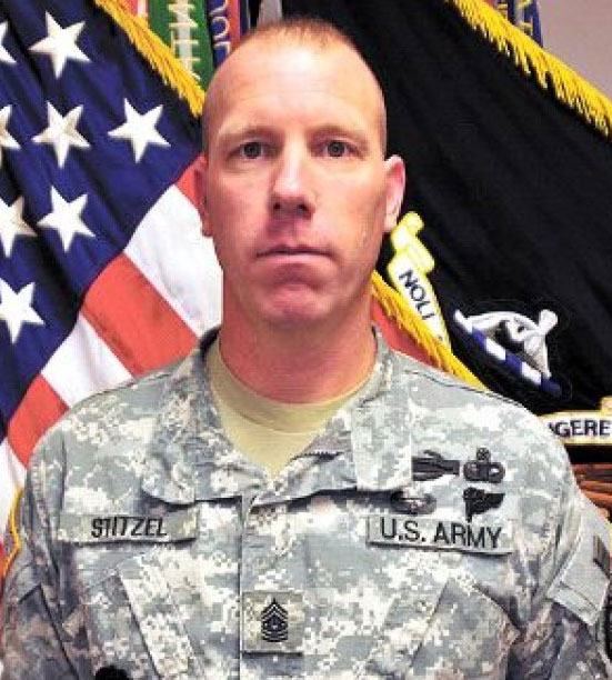 Jeff Stitzel in uniform with flags in background.